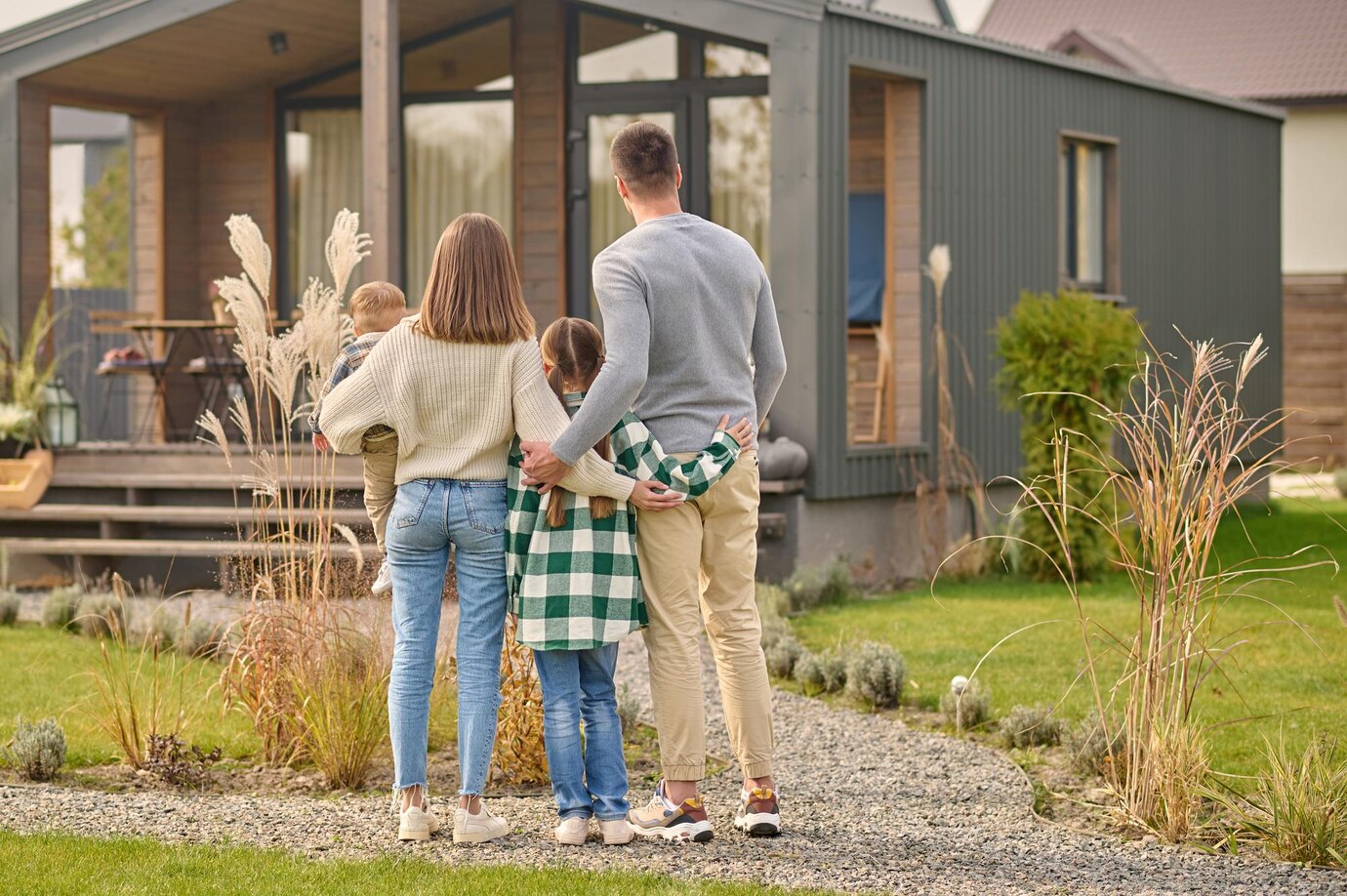 back-view-family-hugging-admiring-their-home_259150-59357