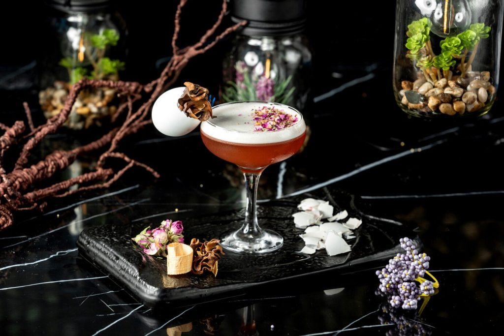 glass-foamy-cocktail-garnished-with-dried-rose-petal-pieces-egg-shell_140725-6032