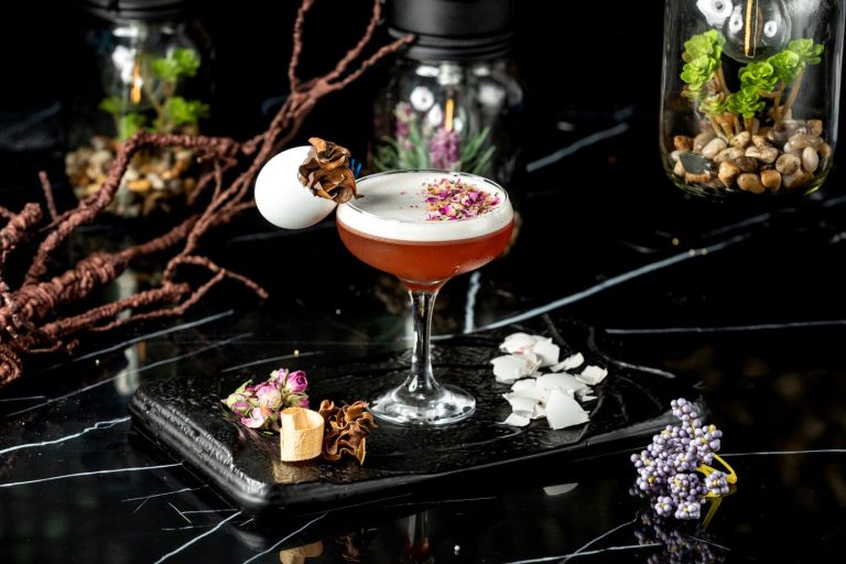 glass-foamy-cocktail-garnished-with-dried-rose-petal-pieces-egg-shell_140725-6032