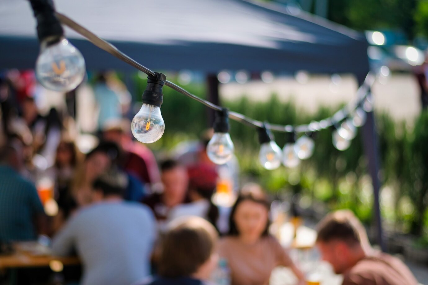 hanged-lamps-outdoor-restaurant-with-multiple-visitors-background-bbq_1268-17681